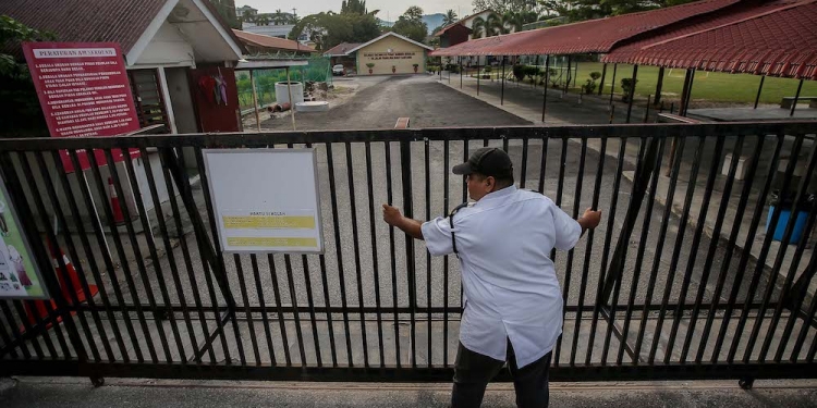 PERAK 17-03-2020.A security guard from SK Panglima Bukit Gantang Ipoh closing the gate of the school as all learning institutions will be closed as Malaysia will be under a nationwide movement control order from this Wednesday (March 18) until March 31 due to the Covid-19 outbreakMALAY MAIL/Farhan Najib