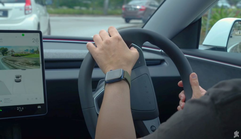 Pressing left button on the Model 3 steering wheel to exit from a roundabout